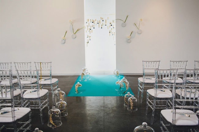bell jars and gold feathers as aisle decorations