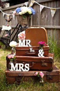 use suitcases at weddings stacked up to display signs and props