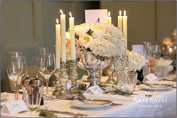 Mercury silver candle sticks around stunning silver footed vases of hydrangeas and roses