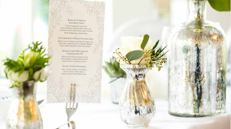 Mercury silver vases on wedding tables with cream and grey flowers