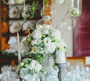 grey urn wedding centrepiece with hanging glass vases and candle holders