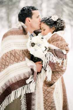 warm and cosy wedding photos bride and groom with blanket