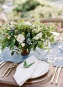 white-and-green-wedding-centrepiece-in-rustic-urn-218x300