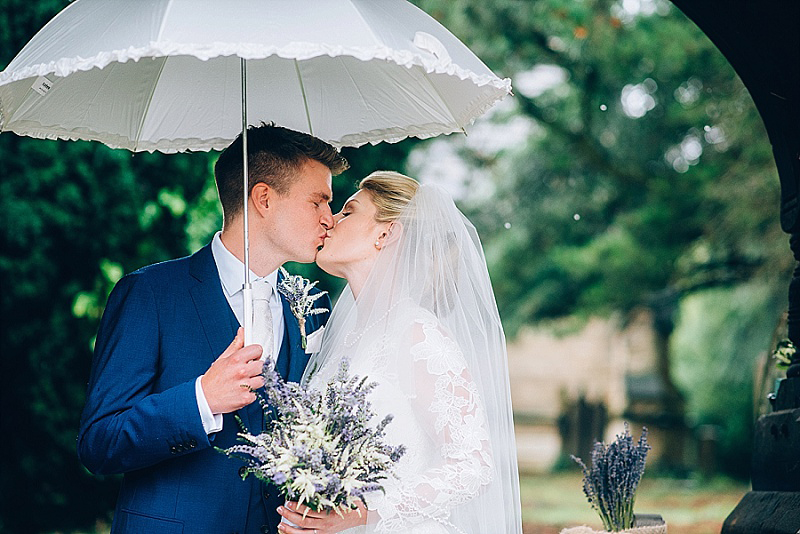 Bride and groom having a lovely day in the rain love the white umbrella