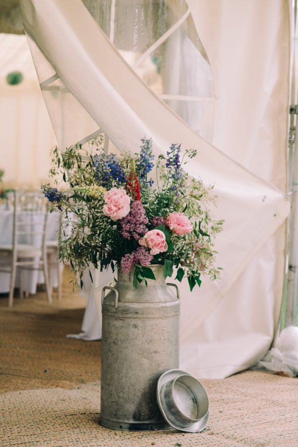 decorate marquee flowers in milk churns