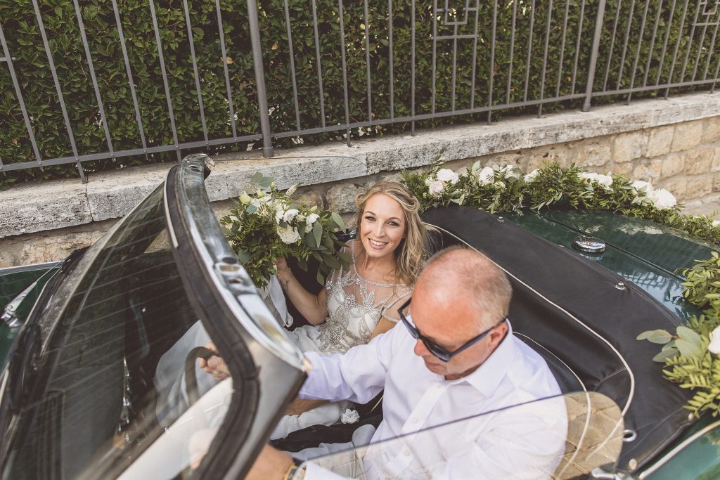 Bride and father of the bride wedding car floral garland Destination wedding Italy Tuscany