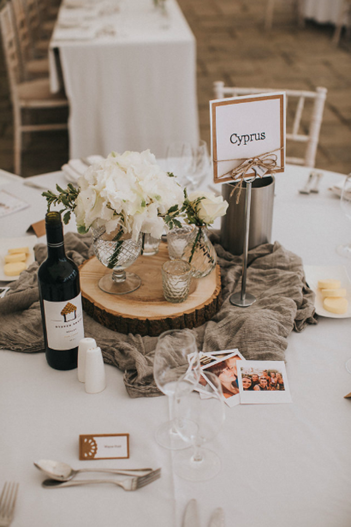 Rustic elegant centrepieces tree slices with gass vases and grey runner Birtsmorton Court Marquee wedding