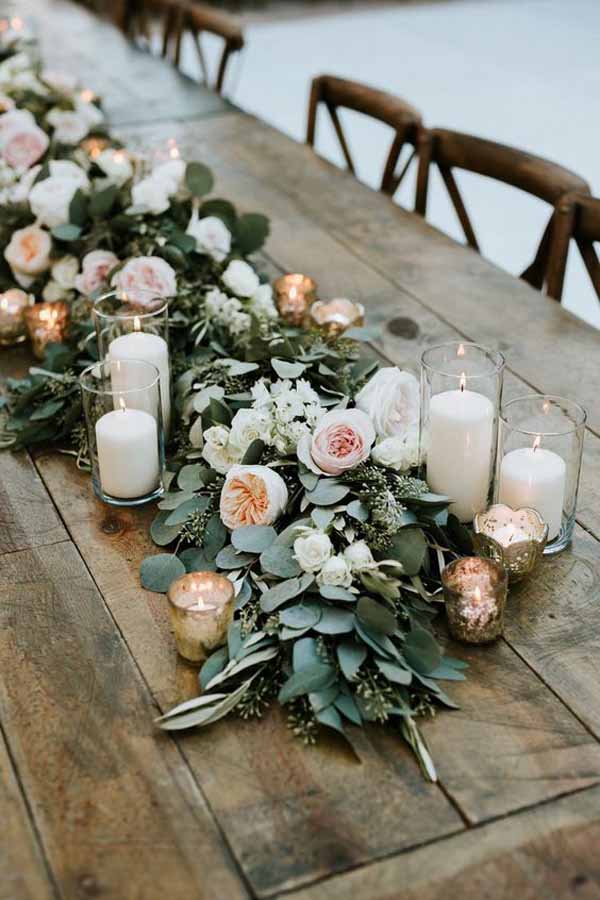 barn wedding centrepieces lush floral garlands with cylinder vases lanterns