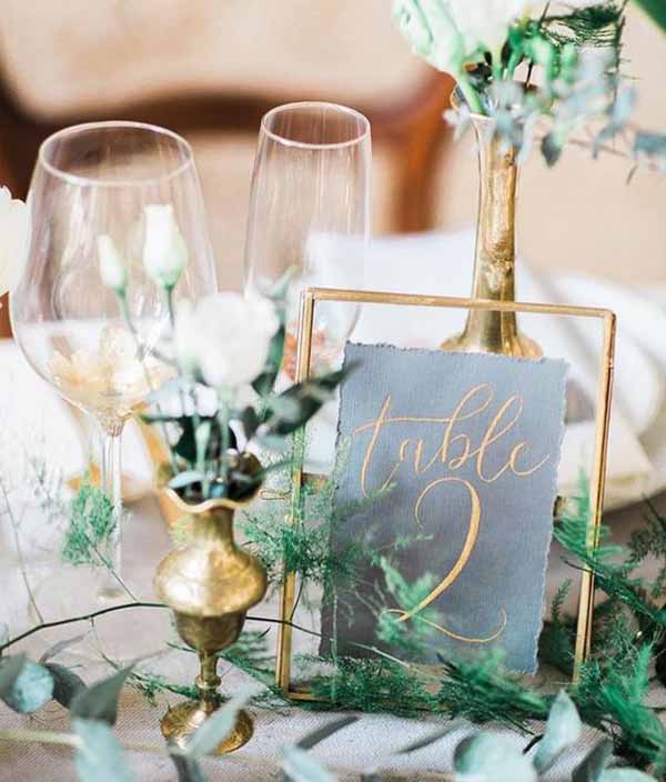 barn wedding with gold table numbers in frames