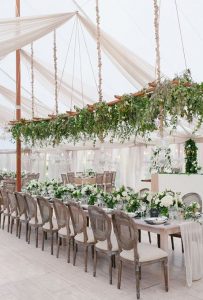 green foliage hanging wedding flowers above table