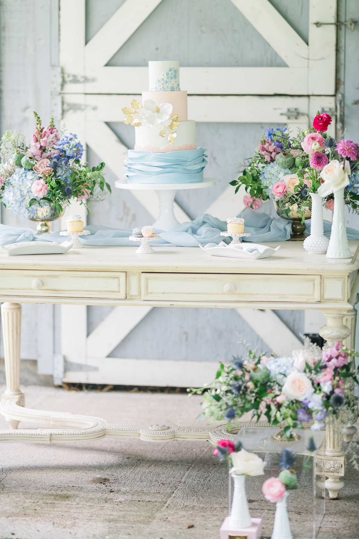 summer barn wedding blue cake table with gold footed bowl wedding flowers centrepieces