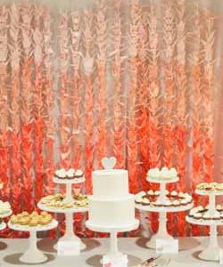 ombre orange paper cranes backdrop behing wedding cake and dessert table