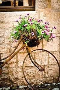 rest a bike with the basket full of wild flowers for an english country garden wedding