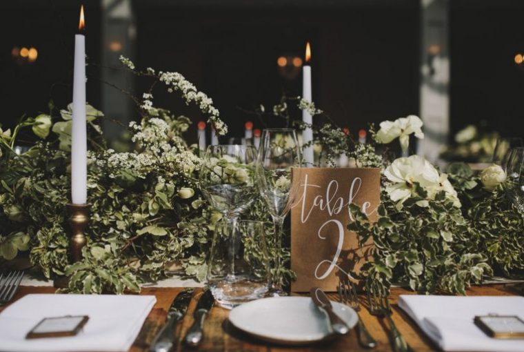 long wedding table garlands brass candlesticks and brown table numbers